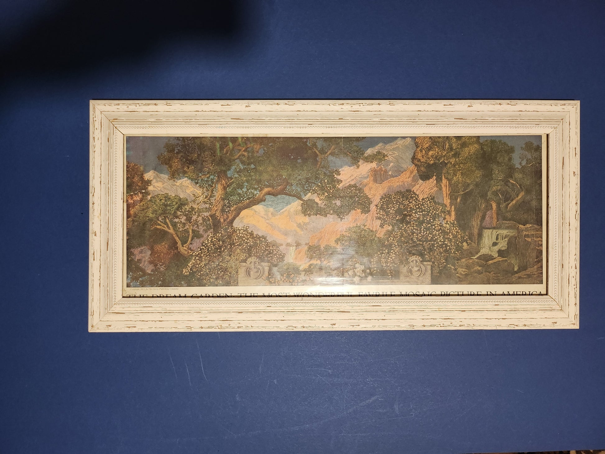 Framed image of Maxfield Parrish's 'Dream Garden' pullout from the 'Ladies' Home Journal' on navy background