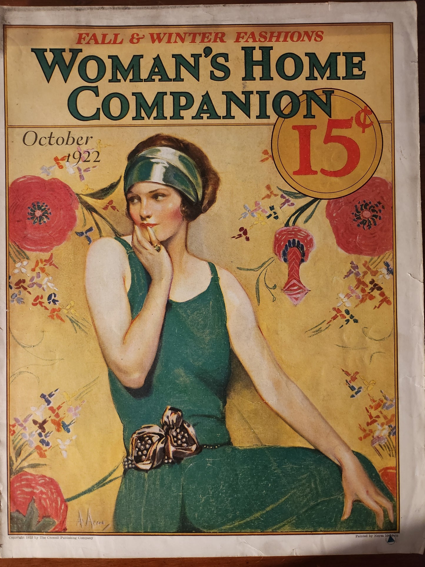 Woman's Home Companion magazine cover from October 1922 with a woman in a green dress and floral decorations by Neysa McMein